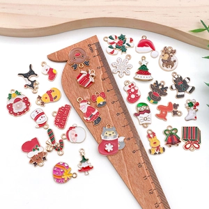 Macro view of Christmas enamel charms on a ruler showing 1-3cm size details