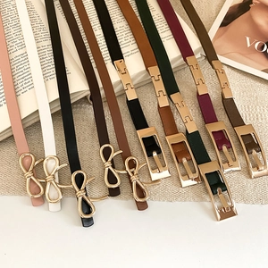 Detail of vintage leather skinny belts with gold bow buckles in various colors and styles