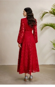 Détail du dos de la robe en dentelle rouge avec manches lanternes et une longue jupe plissée