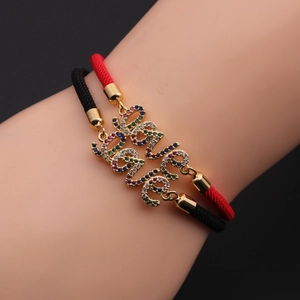 Detailed shot of woven LOVE bracelets in red and black with colorful crystal settings