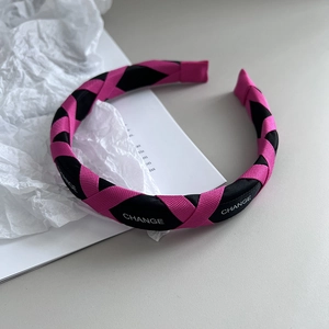 Detail of candy-colored braided headband with sponge padding and 'CHANGE' letter design
