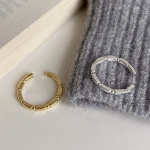 Detail of silver S925 stamped minimalist bamboo style open ring on soft fabric