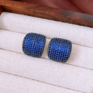 Macro shot of blue zircon square stud earrings in cushion-cut style and luxury setting
