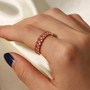 Nahaufnahme eines Goldrings mit rosa ovalen Zirkonia auf beigem Seidenhintergrund