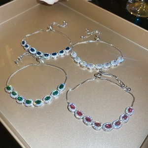 Détail de bracelets réglables en zircon bleu, blanc, vert et rouge avec finition argent