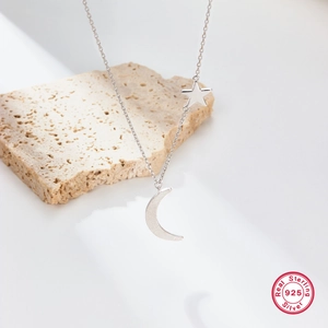 Elegant S925 sterling silver necklace with moon and star pendants on stone texture