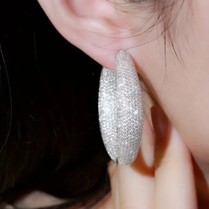 Close-up of large silver hoop earrings featuring micro-pave cubic zirconia on a model