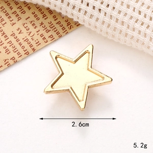 Macro shot of 2.6cm gold star shoe charm on white textured fabric background