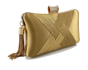 Close-up of golden woven satin evening clutch bag with rhinestone clasp and chain tassels