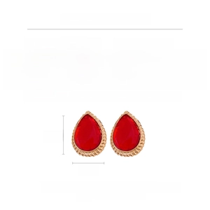 Detail view of large red resin teardrop earrings with golden braided alloy frames and silver posts
