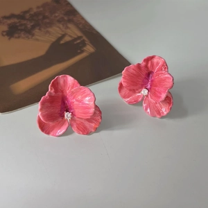 Close-up of pink 14K gold plated petal earrings with sparkling crystal centers
