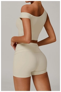 Détail du haut de yoga asymétrique et du short taille haute en tissu mat crème