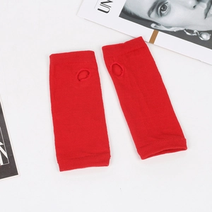 Macro detail of red knitted arm warmers featuring thumb hole and fingerless design