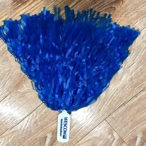 Vibrant blue cheerleading pom-poms with white flat handle on a wooden floor background