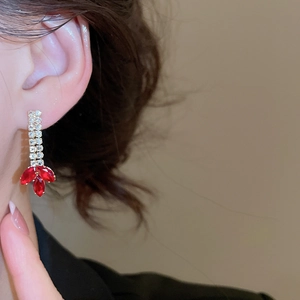 Close-up of red petal tassel earrings with double zircon chain on a model's ear