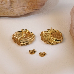 Golden geometric stud earrings with radial fireworks texture on a natural stone background
