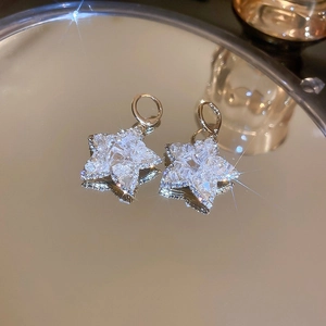 Detailed view of silver star earrings with crystal inlay and mirrored reflection