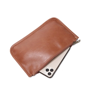 Vue détaillée de la pochette intérieure en cuir marron avec fermeture éclair et téléphone