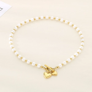 Detailed shot of pearl necklace with gold heart pendants and OT toggle clasp closure