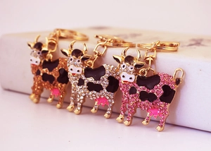 Detail view of four colored cow keychains with rhinestones and enamel finishes