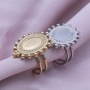 Detail of bohemian geometric oval rings in gold and silver finish on silk fabric