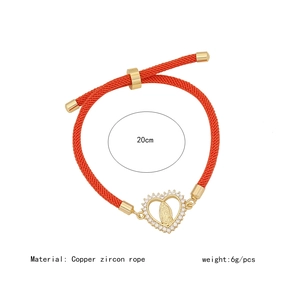 Close-up of a red woven rope bracelet with a gold-plated copper and zircon pendant