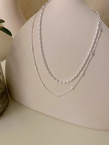 Dettaglio di collana a doppio strato in argento con sfere lucide e piccoli cubi scintillanti