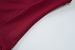 Detail of burgundy backless dress showing refined knit fabric and precision stitching