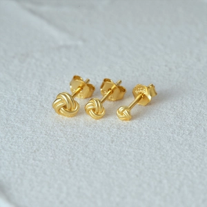 Macro shot of three graduated gold-plated knot earrings with S925 sterling silver hallmarking