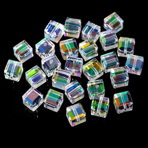 Macro detail of aurora AB cubic glass beads with faceted surfaces and central holes