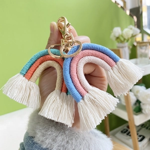 Detail showing handmade macrame rainbow keychains with colorful cotton rope and gold clasps