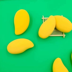 Set of 5 mango-shaped makeup sponges in yellow on green background, latex-free beauty puff