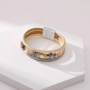 Detail of multi-layer leather bracelet featuring starfish, sea turtle charms and pearls