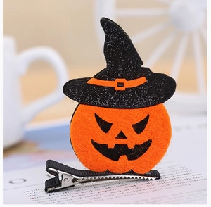 Detail of Halloween pumpkin hair clip with glittery witch hat on a vintage book