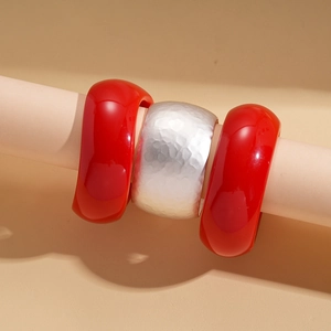 Three-piece acrylic and silver metal bangle set with red glossy and hammered textures