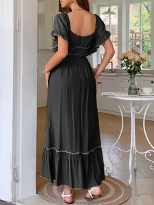 Détail de robe longue noire avec poignets à volants et liseré blanc vus de l'arrière