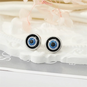 Macro shot of colorful resin Evil Eye stud earrings on an elegant white plaster tray