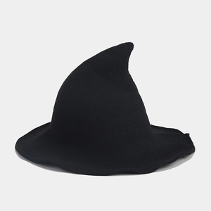 Macro detail of the dense knitted texture and wide brim of the black pointed wizard hat