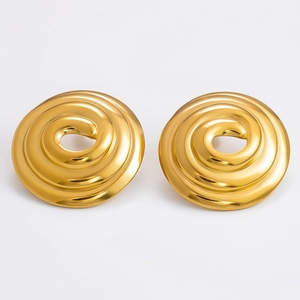 Macro detail of large gold geometric spiral stud earrings with polished metal finish