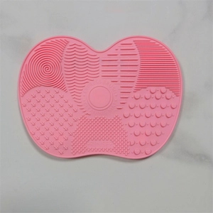 Pink heart-shaped silicone makeup brush cleaning mat with varied washing textures