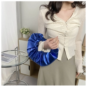 Nahaufnahme einer blauen plissierten Handtasche mit Metalleffekt im modischen Stil