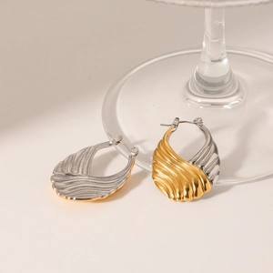 Two-tone gold and silver stainless steel hoop earrings with textured wavy design