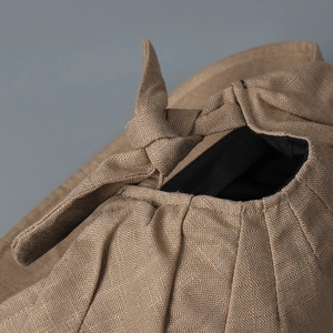 Close-up of brown cotton linen cap showing woven texture and bow detail
