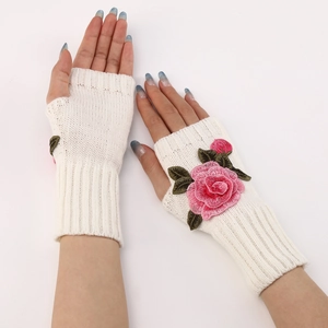 Detail of white knitted fingerless gloves with delicate pink rose floral embroidery