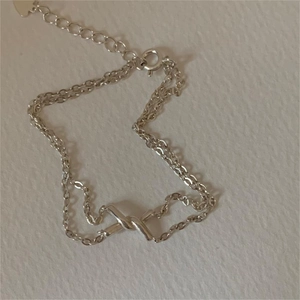 Double-layered 925 sterling silver twist bracelet with center cross knot and heart charm
