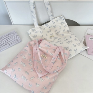 Detail of canvas tote bags with cute cat prints and sturdy shoulder straps in soft colors