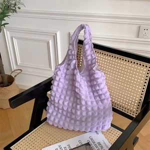 Detail of lavender bubble textured tote bag with elastic 3D fabric on a rattan chair