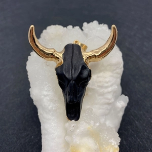 Detailed view of acrylic bull skull pendant with gold horns and black finish for DIY jewelry