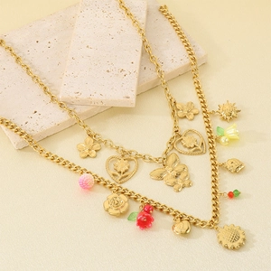 Détail de colliers en acier inoxydable doré avec breloques de fleurs et papillons en émail