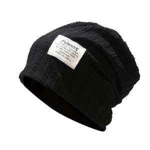 Classic black cable-knit slouchy beanie with a vintage cloth patch for autumn and winter